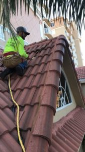 New tile roofing is installed by a worker.
